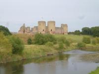 a castle sitting on top of a hill next to a river at Garden Suite in Rhuddlan