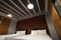 two beds in a room with a brick wall at Ji Ye Jing Zhan B&amp;B in Ji&#39;an