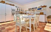 a kitchen with white cabinets and a table and chairs at Nice Home In Verfeuil With Wifi, Private Swimming Pool And Outdoor Swimming Pool in Verfeuil