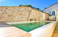 a swimming pool in front of a stone wall at Nice Home In Verfeuil With Wifi, Private Swimming Pool And Outdoor Swimming Pool in Verfeuil