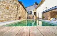 a swimming pool with a wooden deck and a house at Nice Home In Verfeuil With Wifi, Private Swimming Pool And Outdoor Swimming Pool in Verfeuil