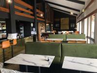 un restaurante con mesas y cabinas verdes y un bar en Lakeside Falls Creek, en Falls Creek
