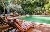 a swimming pool with two lounge chairs next to a swimming pool at Lovely Home In Roujan With Outdoor Swimming Pool in Roujan