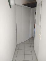 an empty hallway with white walls and white tile floors at Appartement residence le nautile in Le Grau-du-Roi