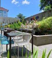 un tavolo, delle sedie e una fontana in un giardino di Zuri Express Jimbaran a Jimbaran