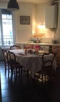 a kitchen with a table with chairs and a table cloth at Berges du Rhône&#47; Chambre avec balcon in Lyon