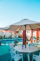 una mesa con sombrilla junto a la piscina en Courtesy Apartments Aruba, en Oranjestad