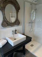 a bathroom with a white sink and a mirror at Kermaria Studio Suite in Pont-Aven