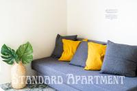 a couch with yellow and blue pillows and a plant at Eiffel Tower view Residence in Paris