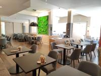 un ristorante con tavoli e sedie e una parete verde di Hotel Stempferhof a Gössweinstein