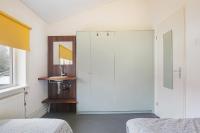 a bedroom with a white closet and a mirror at Hello Zeeland - Appartement Beatrixstraat 27 in Domburg