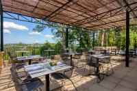 un patio con mesas y sillas en una terraza en Hôtel & restaurant Le Meysset, en Sarlat-la-Canéda