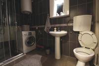 a bathroom with a toilet and a sink and a washing machine at TOP Apartman in Šabac