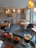 LanasにあるAuberge du Vieux Lanas Logis Hotel Restaurantの木製のテーブルと椅子、aasteryasteryasteryasteryasteryasteryasteryasteryasteryのあるレストラン