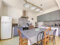 a kitchen with a table and chairs and a refrigerator at Mas Jeannot 8 personnes in Noves