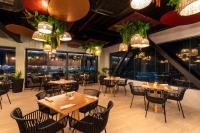 Un restaurante con mesas y sillas y grandes ventanales. en Sea Avenue Hotel, en San Andrés