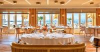 a dining room with tables and chairs and windows at Roslin Beach Hotel in Southend-on-Sea