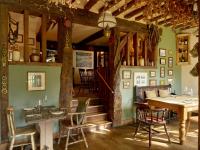 a dining room with a table and chairs at The Plough Inn in Stalisfield