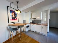 a kitchen with white cabinets and a table and chairs at 501 - Charmant studio dans un immeuble Paris 5 in Paris