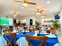 トゥスパン・デ・ロドリゲス・カノにあるHotel Bokettoの青いテーブルと椅子、天井扇風機のあるダイニングルーム