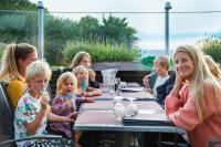 a group of women and children sitting at a table at Hotell och Restaurang Hovs Hallar in Båstad