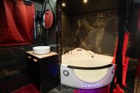 a small bathroom with a tub in a room at Capsule Secret - Jacuzzi - Netflix &amp; Home cinéma - Jeux de couple - Barre de pole dance in Valenciennes