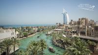 a river in the middle of a city with palm trees at Jumeirah Mina Al Salam Dubai in Dubai