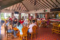 a group of people sitting at tables in a restaurant at CASA BOHEMIA - Resort de Cerveza y vino in Campoalegre