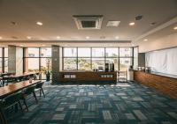 a restaurant with tables and chairs and windows at Hotel Sweet Castle Jeju Hamdeok in Jeju