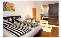 a bedroom with a bed with a black and white striped sheets at Ferienhaus Reiter Jochberg bei Kitzbühel in Jochberg