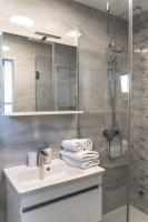 a bathroom with a sink and a shower with towels at Comfort Apartment Dorin in Makarska