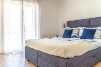 a bedroom with a large bed with blue pillows at Comfort Apartment Dorin in Makarska