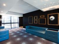 a living room with a blue couch against a black wall at Lutecia Smart Design Hotel in Lisbon