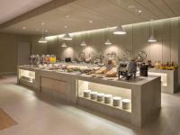 a kitchen with a buffet of food on display at Elsotel Purwokerto By Daphna Management in Purwokerto