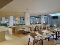 a dining room with tables and chairs in a restaurant at Elsotel Purwokerto By Daphna Management in Purwokerto