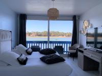 Un dormitorio con una cama con una ventana grande. en Le Relais Du Lac, en Hossegor
