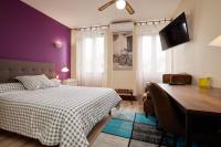 Un dormitorio con una cama y un escritorio con una computadora. en hotel de la paix, en Pamiers