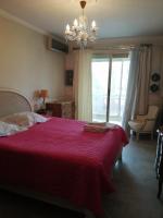 a bedroom with a bed with a red blanket and a chandelier at Cannes Mimosas One Bedroom in Cannes