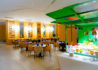 a restaurant with tables and chairs and a video game at Mercure Kuala Lumpur Glenmarie in Shah Alam