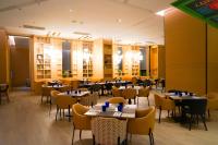 a restaurant with tables and chairs in a room at Mercure Kuala Lumpur Glenmarie in Shah Alam