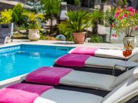 two lounge chairs next to a swimming pool with pink and white cushions at Holiday Home Villa Orhidea by Interhome in (( Marčići ))