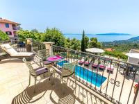 a balcony with a table and chairs and a pool at Holiday Home Villa Orhidea by Interhome in (( Marčići ))