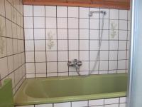 a green bath tub in a tiled bathroom at Appartement Weingut Schoberhof in Bad Gleichenberg