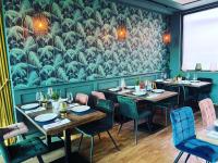 Un comedor con mesas y sillas y un mural. en ARGENTA Living 131, en Künzell