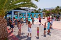 a group of people standing around a pool at a resort at Corali Hotel in Tigaki