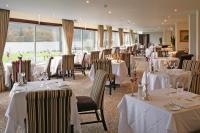 ボウネス・オン・ウィンダミアにあるマクドナルド オールド イングランド ホテル＆スパの白いテーブルクロスがかけられたテーブルと椅子のあるレストラン