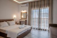 a bedroom with a bed and a large window at Anastasia&#39;s Studios in Polykhrono