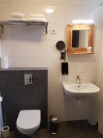 a bathroom with a white toilet and a sink at Stad &amp; Strandhotel Elisabeth in Vlissingen