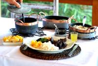 een tafel met drie potten en een bord met eten bij Pousada Encanto da Bocaina - Serra da Bocaina in São José do Barreiro