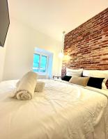 a large white bed in a room with a brick wall at Le Grand Canyon in Saint-Étienne